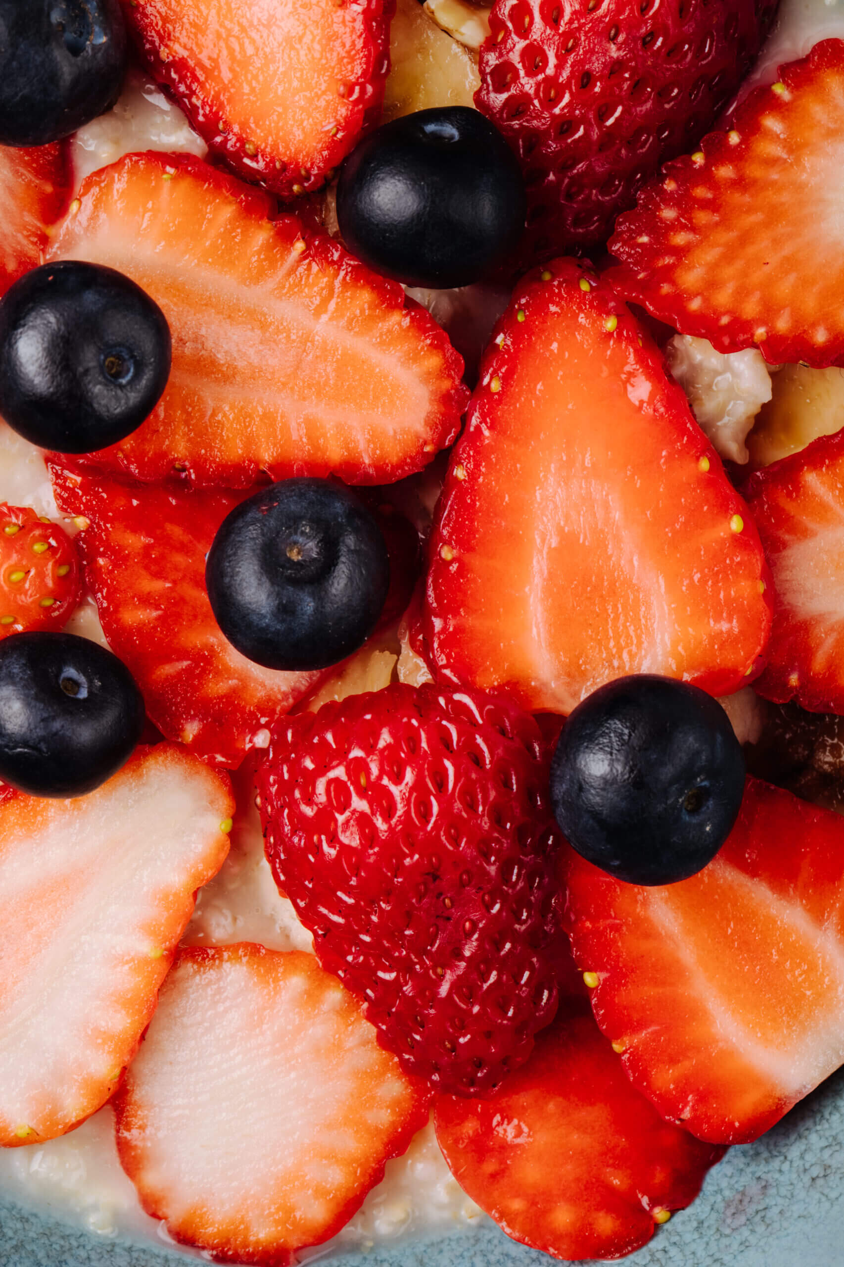 close up view of oatmeal porridge with sliced strawberries blueberry in a ceramic bowl Fresas y cerezas fruta de temporada